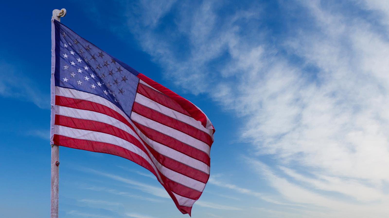 illustration of American Flag waving in sky backdrop