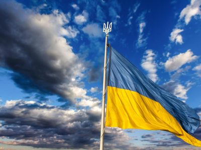 Large national flag of Ukraine flies in the blue sky. Big yellow blue Ukrainian state banner. Independence, flag, Constitution Day, National Holiday, text space